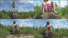 Redhead babe pees over a massive rock outside