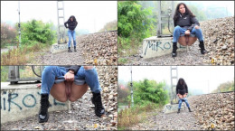 Ali B squats and pees near the train tracks