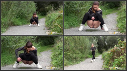 Cute European squatting to pee on a path